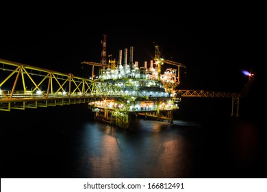 The Large Offshore Oil Rig At Night With Twilight Background