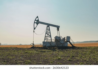 Un Grande gato bomba de aceite funciona en campo abierto, extrayendo petróleo crudo