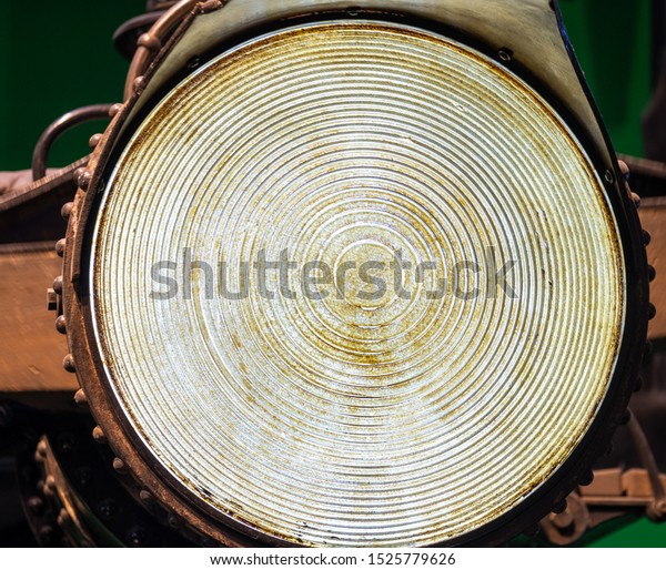 A large old fashioned headlamp. Big round\
electrical light with grooves and a bit of grime to give it a real\
worn and rustic look. Brighter days, bright ideas, shine on an\
outlook or future.