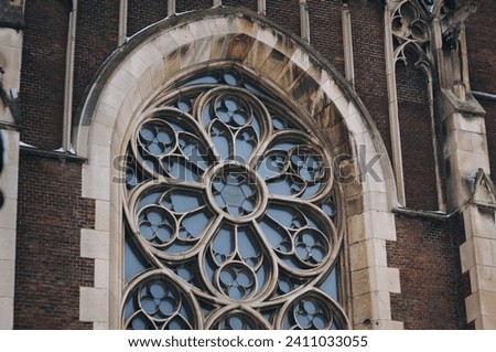 Large old vintage openwork round window with stained glass on facade of the building. Baroque and Gothic architecture. Church of St. Olga and Elizabeth. Lviv, Ukraine. Stock photo © 