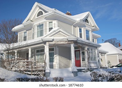 A Large Older Home Covered With Snow.