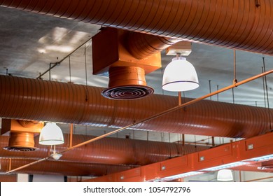 Large Orange Air Duct In The Exhibition Hall Installed On The Ceiling. And Lighting For Interior Lighting.