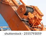 A large orange crane with wire rope sling or cable sling on crane reel drum or winch roll of crane the lifting machine in heavy industrial.