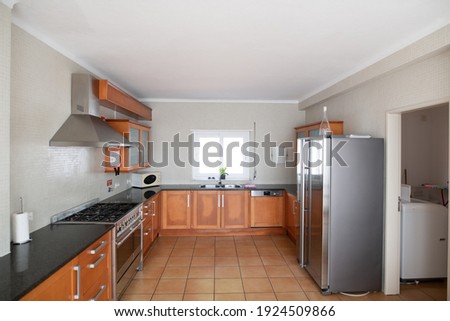 Large but outdated kitchen with wooden cabinets and granite counter top