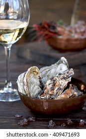 
Large oysters in ice and white wine in a glass. A gourmet dinner or lunch