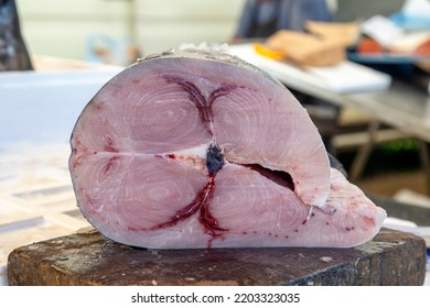 Large piece of raw swordfish on a cutting board at farmer market, Nikiti, Sithonia, Greece. Selective focus.