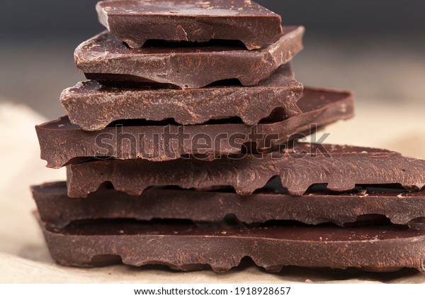 large pieces of bitter chocolate with cocoa\
and butter, divided into pieces a piece of chocolate from cocoa,\
bitter chocolate broken into\
pieces