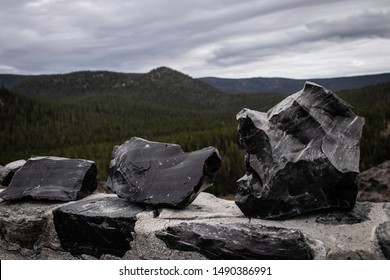 Large pieces of obsidian rock sit atop a ledge on the Big Obsidian Flow hike in the Newberry Volcanic National Monument in central Oregon.  - Shutterstock ID 1490386991