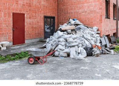 A large pile of construction debris after repair lies near a brick building