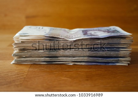 A large pile of money in bank notes, giving the impression of wealth.