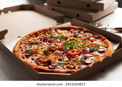 Large Pizza in open carton box and cutter on kitchen table closeup view - Powered by Shutterstock