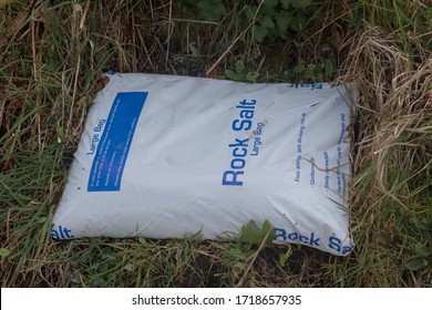 Large Plastic Bag Of Rock Salt For Deicing A Road In Cold Weather And Snow In A Roadside Verge In Rural Devon, England, UK
