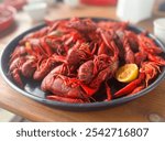 Large platter of freshly boiled crawfish served with lemon slices, showcasing a traditional seafood dish. The vibrant red crawfish is arranged on a rustic wooden table, capturing the essence.