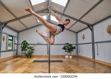 large pole dance studio with dancing instructura suspended in the air. - Powered by Shutterstock