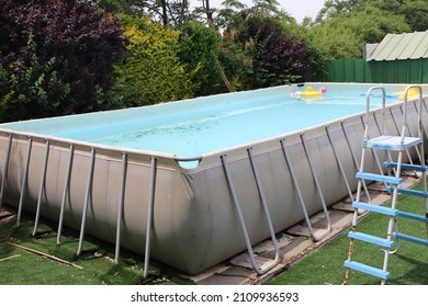 Large Pool Full Of Water Among The Trees In The Backyard. Pool On Pillars.Empty Above Ground Swimming Pool In A Backyard