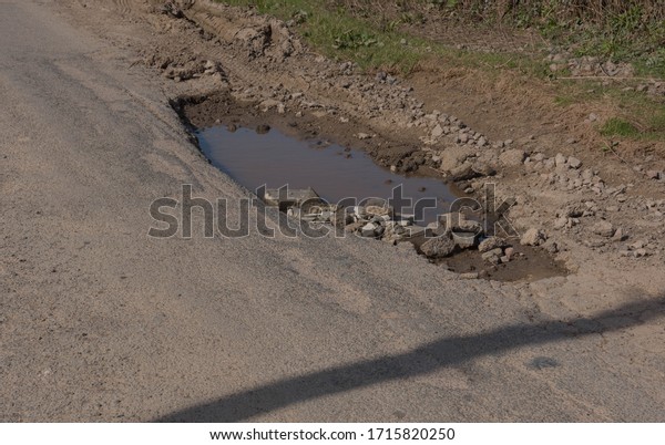 Large Pothole on a Country Road in Rural Devon,\
England, UK