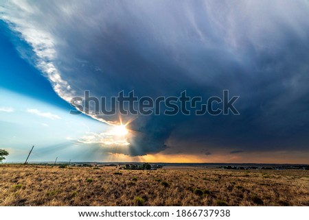 Large, powerful tornadic supercell storm moving over the Great Plains during sunset, setting the stage for the formation of tornados across Tornado Alley. 