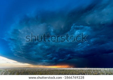 Large, powerful tornadic supercell storm moving over a field in Oklahoma sets the stage for the formation of tornados across Tornado Alley. 