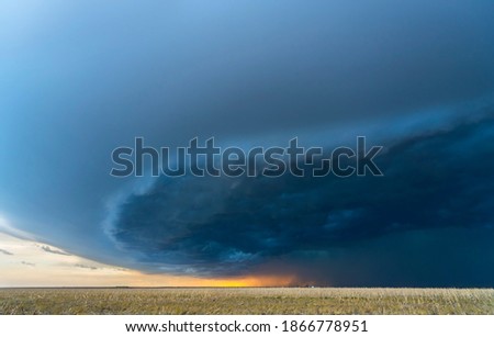 Large, powerful tornadic supercell storm moving over a field in Oklahoma sets the stage for the formation of tornados across Tornado Alley. 