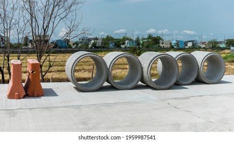 Large Precast Concrete Pipe Segments Prepared On A Road For Sewage, Storm Drain Or Water Supply Project.