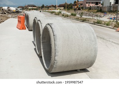 Large Precast Concrete Pipe Segments Prepared On A Road For Sewage, Storm Drain Or Water Supply Project.