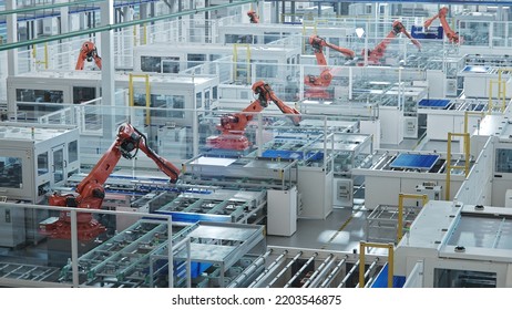 Large Production Line With Industrial Robot Arms At Modern Bright Factory. Solar Panels Are Being Assembled On Conveyor. Automated Manufacturing Facility