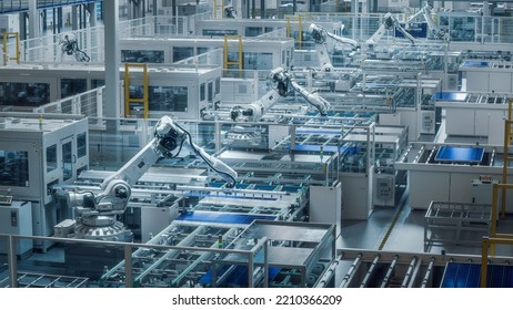 Large Production Line with White Industrial Robot Arms at Modern Bright Factory. Solar Panels are being Assembled on Conveyor. Automated Manufacturing Facility. - Shutterstock ID 2210366209