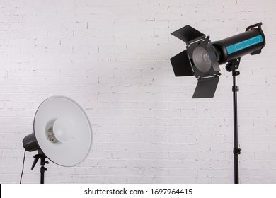 Large Professional Photo Studio Lamps On A White Brick Wall.