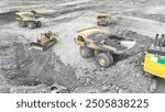 Large quarry dump truck. Big yellow mining truck at work site. Loading coal into body truck. Production useful minerals. Mining truck mining machinery to transport coal from open-pit production