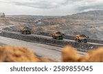 Large quarry dump truck. Big yellow mining truck at work site. Loading coal into body truck. Production useful minerals. Mining truck mining machinery to transport coal from open-pit production.