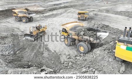 Large quarry dump truck. Big yellow mining truck at work site. Loading coal into body truck. Production useful minerals. Mining truck mining machinery to transport coal from open-pit production