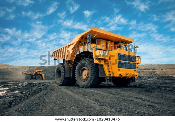 A large quarry dump truck in a coal mine.\
Loading coal into body work truck. Mining equipment for the\
transportation of minerals.