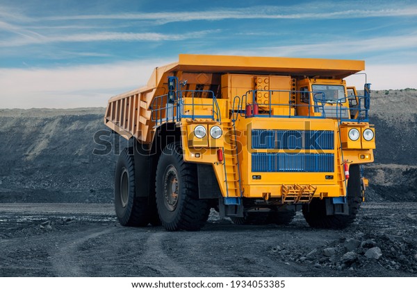 A large quarry dump truck in a coal mine.\
Loading coal into body work truck. Mining equipment for the\
transportation of minerals.