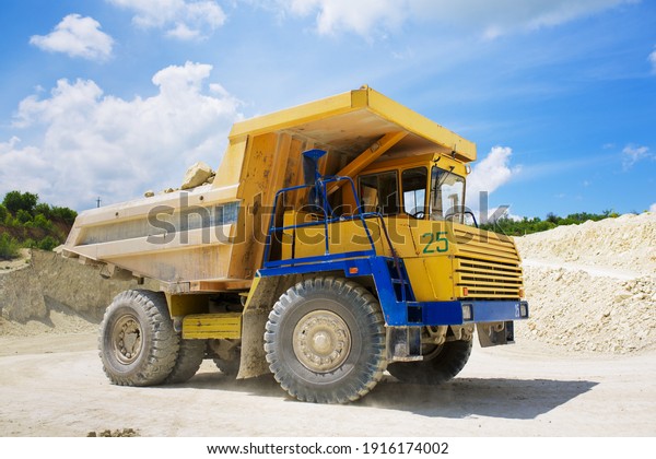 A large quarry\
dump truck loaded with rock