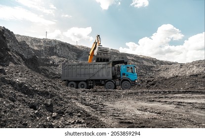 Large quarry dump truck. Loading the rock in dumper. Loading coal into body truck. Production useful minerals. Mining truck mining machinery, to transport coal from open-pit as the Coal Production