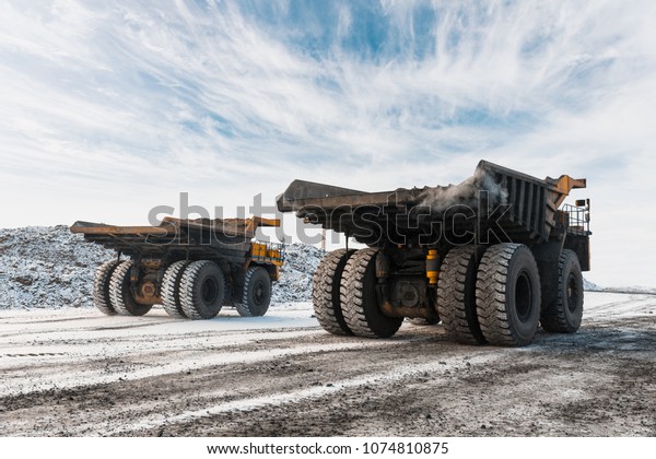 Large quarry dump truck. Loading the rock in\
dumper. Loading coal into body truck. Production useful minerals.\
Mining truck mining machinery, to transport coal from open-pit as\
the Coal Production.