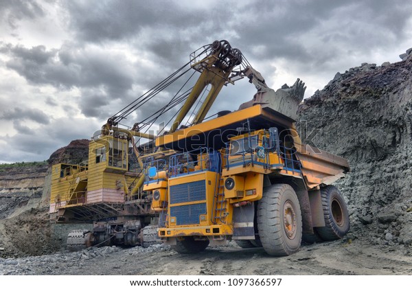 Large quarry dump truck. Loading the\
rock in the dumper. Loading coal into body work truck. Mining truck\
mining machinery, to transport coal from\
open-pit