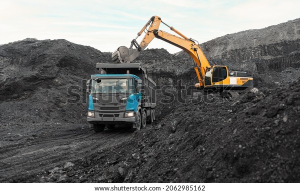 Large quarry dump truck. Loading the rock in\
dumper. Loading coal into body truck. Production useful minerals.\
Mining truck mining machinery, to transport coal from open-pit as\
the Coal Production