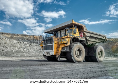 Large quarry dump truck. Transport industry. A mining truck is driving along a mountain road. Quarry truck carries coal mined.
