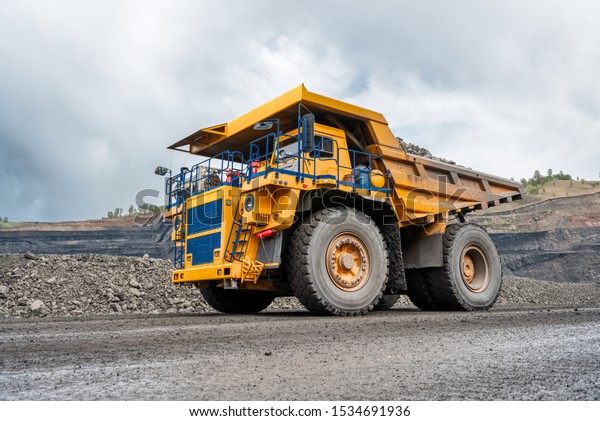 Large quarry dump truck. Transport industry. A\
mining truck is driving along a mountain road. Quarry truck carries\
coal mined.