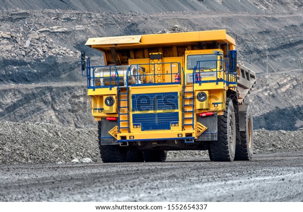 Large quarry dump truck. Transport industry. A\
mining truck is driving along a mountain road. Quarry truck carries\
coal mined.