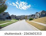 Large and quiet residential street in downhill upscale neighborhood with two and three story new development suburban single family home suburbs of Atlanta, Georgia, USA. Subdivision HOA area