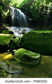 Large Rain Forest Waterfall, Sun Beams, And Mossy Rocks