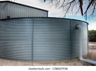 Large rain water tank, ecology friendly, in front of metallic building.