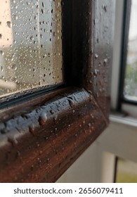 Large raindrops on a window frame during a downpour