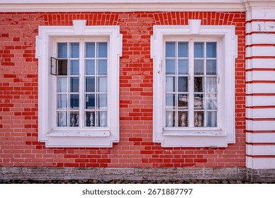 A large rectangular wooden window in a red brick wall.