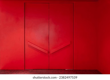 Large red door entrance to the meeting room in a red wall , Red wall texture in hall with modern red door. colorful gate in room