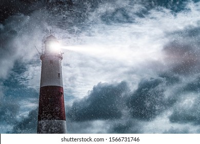 Большой красно-белый маяк в дождь и шторм, наполненный ночью лучом света, сияющим в море