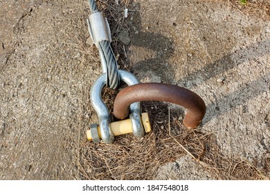 Large Rigging Bracket, Lobe, Shackle. Fastening Of A Twisted Metal Cable To The Installation Embedded Loop In The Concrete Slab.