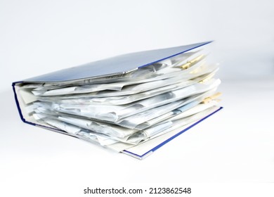 Large ring binder with clear punched pockets full of receipts, office management, accounting and tax calculation, light gray background, copy space, selected focus, narrow depth of field
